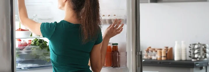 Person schaut in einen Kühlschrank